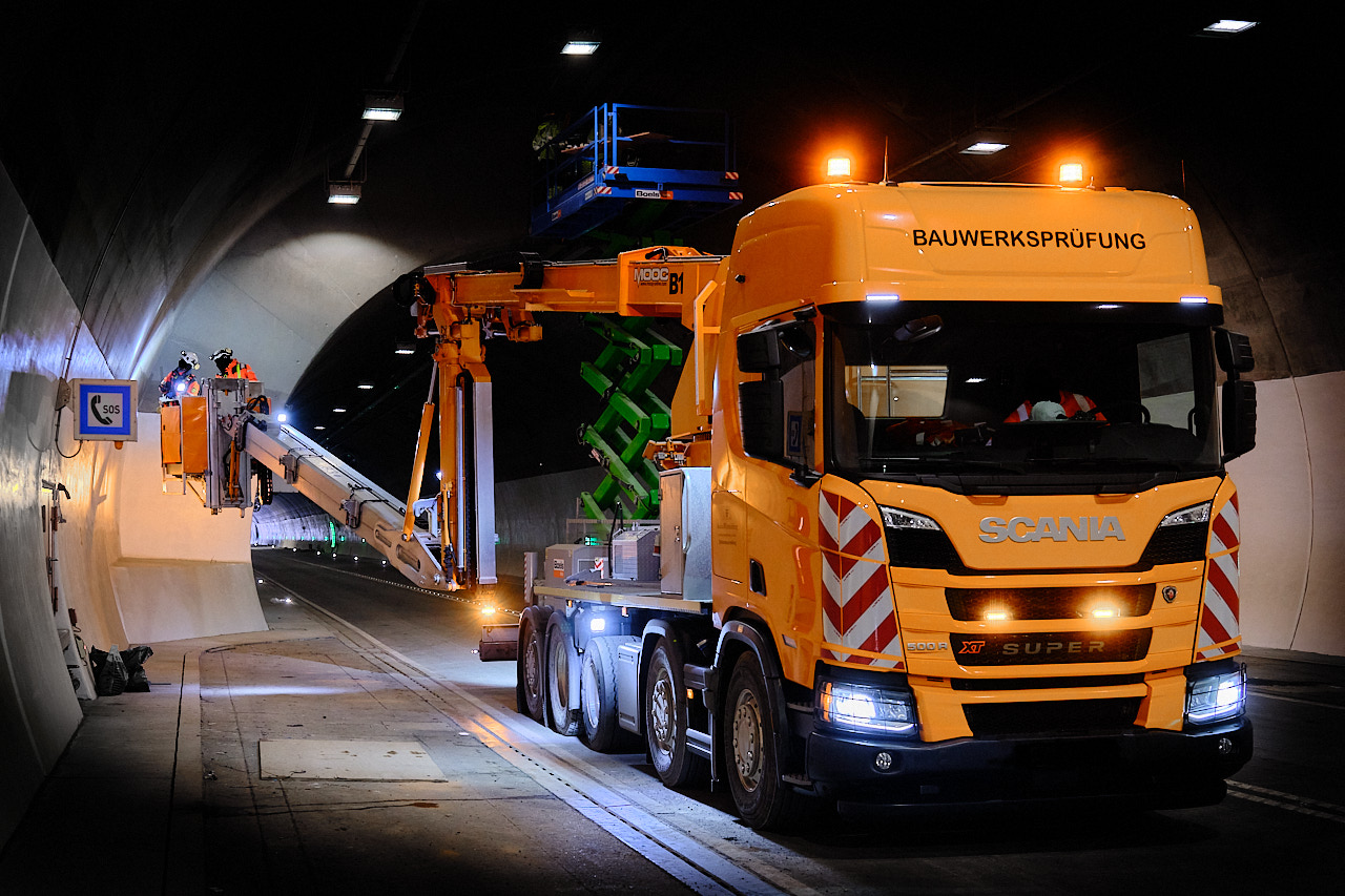 Bauwerksprüfung in einem Straßentunnel mit Arbeitsbühne und Prüffahrzeug – Industriefotografie für eine Unternehmensreportage.